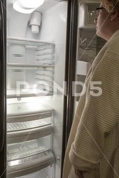 Woman looking at empty refrigerator Stock Photos
