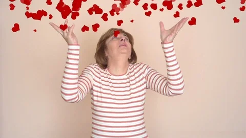 Woman looking up at the hearts falling down Stock Footage 100681332