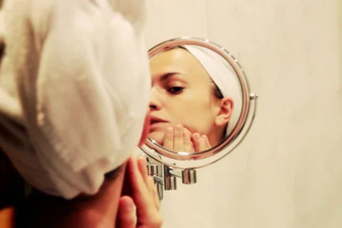 Woman looking at herself in the mirror Stock Footage