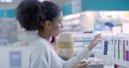 Woman Looking At Medicine In A Box At A Pharmacy, Buying Medication And Reading Stock Footage