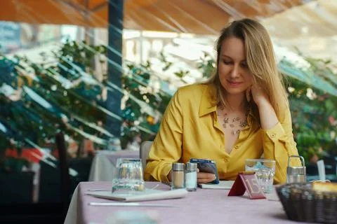 Woman is looking at menu via qr code in restaurant. Stockfoto's