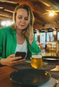 Woman is looking at menu via qr code in restaurant. 写真素材