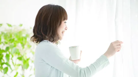 Woman looking out of the window while drinking coffee Video stock 160127637