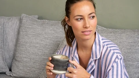 Woman looking outside window drinking hot choco Stock Footage 104930406
