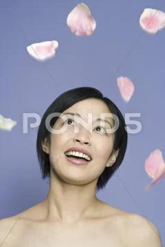 A woman looking at petals falling in mid-air Stock Photos