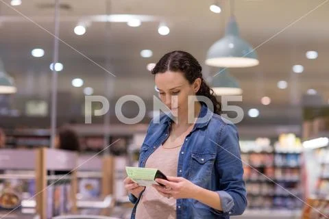 Woman looking at ready meal in grocery store Stock Photos