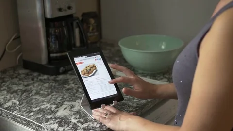 Woman Looking at Recipe on Tablet in Kitchen Vídeo Stock 79606953