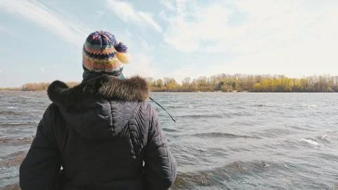 Woman Looking at the River during a Cold Spring Day 写真素材