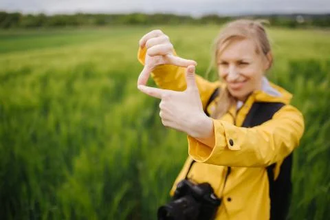 Woman looking for shooting composition through fingers frame Stock-Fotos