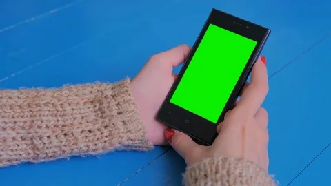 Woman looking at smartphone with green screen Stock Footage