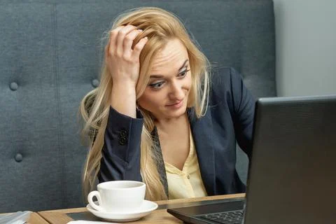 Woman looking surprised while using the laptop. Stock Photos
