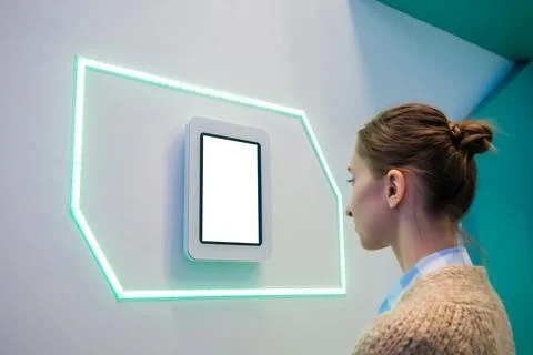 Woman looking at tablet computer with blank white screen at exhibition Stock Photos
