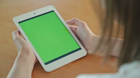 Woman looking at tablet computer with green screen in cafe Stock Footage