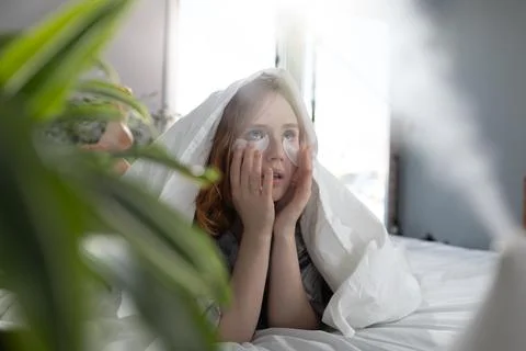 Woman Looking Thoughtfully While Wrapped in a Blanket in a Cozy Indoor Setting Stock Photos