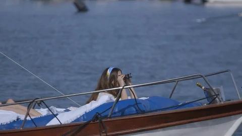 Woman looking through the binoculars while relaxing on boat Stock Footage 89978837