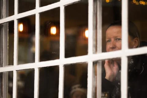 Woman looking through the cafe window Stock Photos