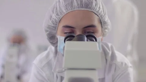 Woman looking through a microscope 動画素材 75165250