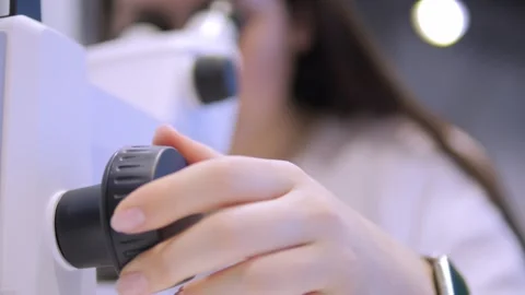 Woman is looking through a microscope Stock Footage 297966676