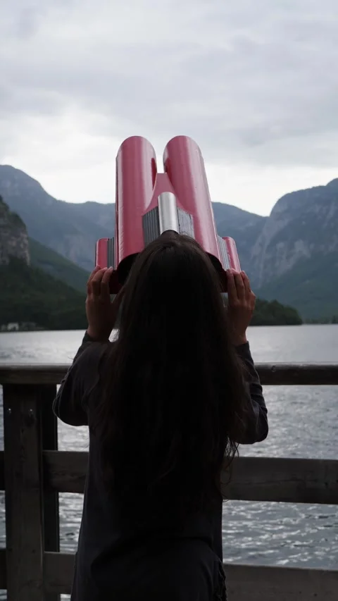 Woman looking through tower viewer at a misty alpine lake Video stock 342640050