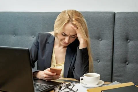 Woman looking upset while using smartphone. Stock Photos