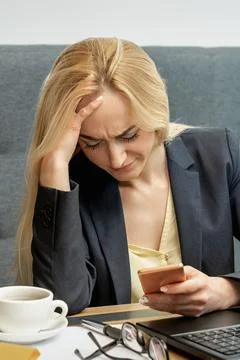Woman looking upset while using smartphone. Stock Photos