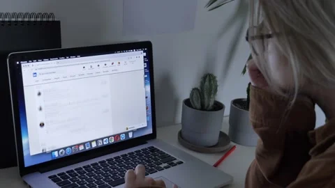 Woman looking for wok at LinkedIn as Java Script developer on laptop at home Stock Footage 166119851