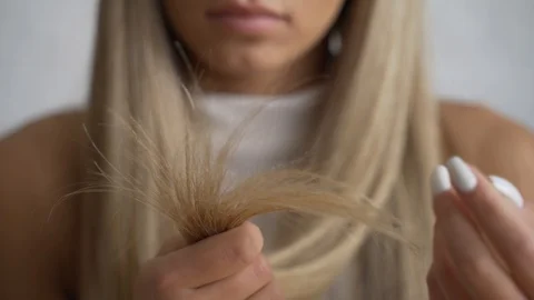 Woman looks desprately at split ends of hair after taking shower. Stock Footage 111511074