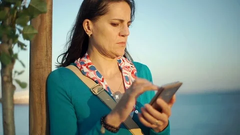 Woman looks dissatisfied while browsing internet on smartphone, steadycam shot Stock Footage