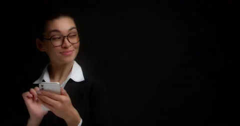 Woman looks at an empty copy space on the right while texting on her phone Stock Footage 194477945