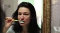 Woman looks into the mirror and brushes teeth in the bathroom HD Footage