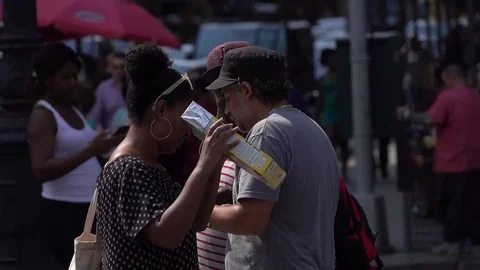 A woman looks at a solar eclipse using solar pinhole viewer Stock Footage 79830689
