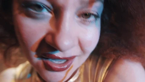 Woman in lush carroty hair wig grimacing and dancing on scene with troupe Stock Footage