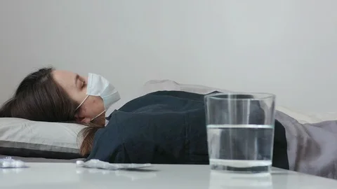 Woman Lying in Bed and Checking Temperature by Thermometer. Coronavirus COVID-19 Stock Footage 127490335