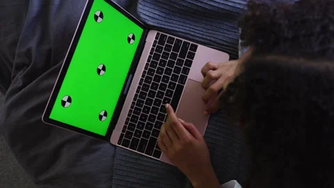 Woman lying in the bed and using a laptop with a green screen Stock Footage 264220078