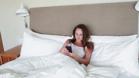 Woman Lying In Bed Checking Messages On Mobile Phone Stock Footage 73377073