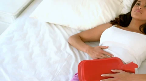 Woman lying in bed with cramps Stock Footage