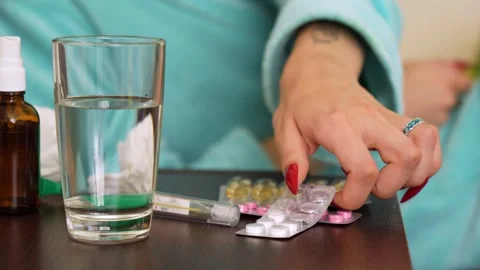 A woman lying in bed taking cold pills Stock Footage 281343196