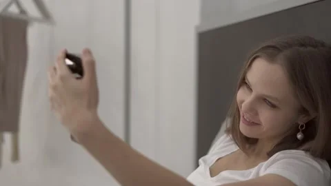 Woman lying on bed using smartphone for video chatting at home Stock Footage 132051066