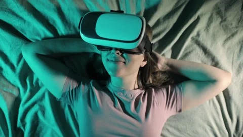 Woman is lying in bed in virtual reality 3d glasses and watching video. 스톡 동영상 146702247