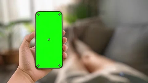 Woman lying on couch using smartphone with green mock up screen chroma key Stock Footage 306170118