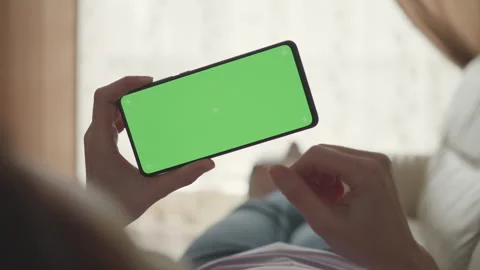 Woman Lying on Couch Using Smartphone With Chroma Key Green Screen Scrollin.. Stock Footage 328883049