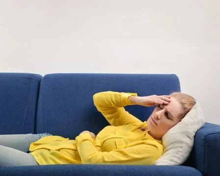 Woman lying down on a sofa, feeling sick Stock Photos