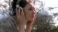 Woman lying on grass with headphones on HD Footage