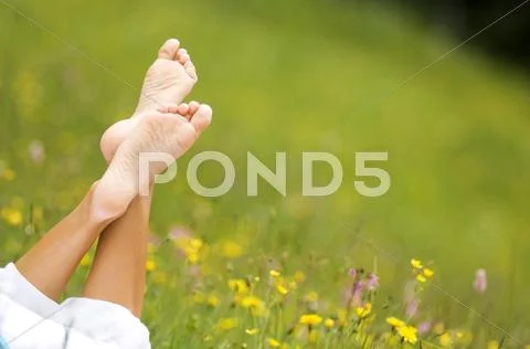 Woman lying in meadow, barefoot Stock Photos