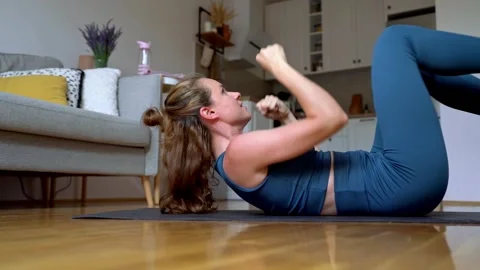Woman lying ob back on exercise mat at home and doing ab exercise Stock Footage 279242990