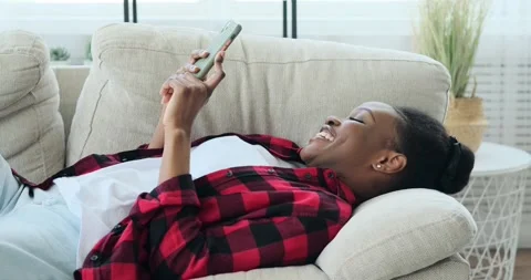 Woman lying on sofa and using mobile phone Stock Footage 155113555