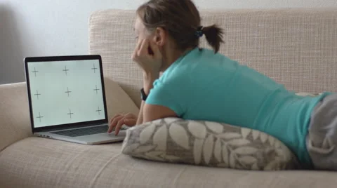 Woman lying on sofa and working on laptop Stock-Footage 68378349