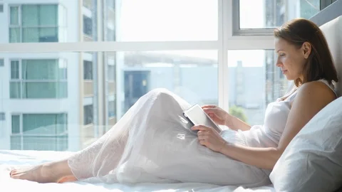 Woman Lying on Sofa Tablet Computer. 4K UHD, Slow Motion Stock Footage 87550534