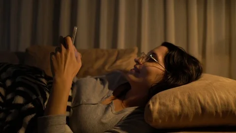 Woman lying on sofa using smart phone 動画素材 121566745