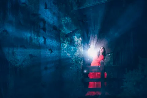 Woman with magic light in a dark forest Stock Photos